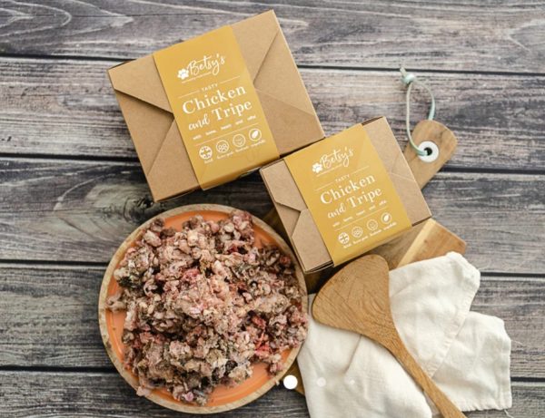 Packaged meals with prepared dish on wooden table